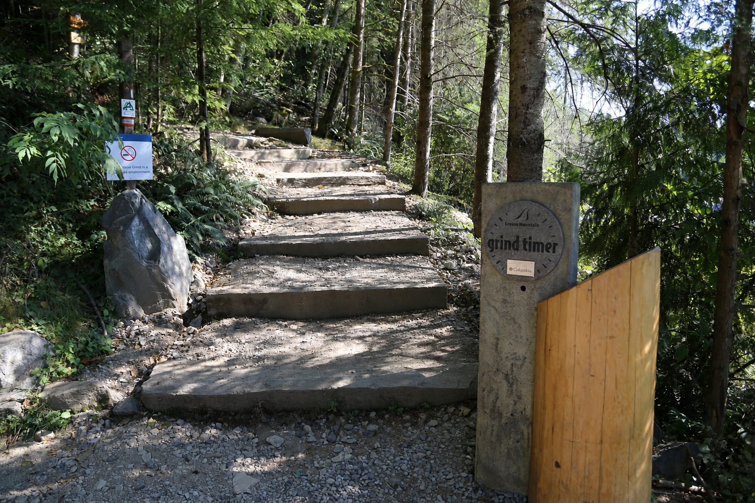 Start of the Grouse Grind Trail, showing the Grind Timer and stairs leading into the forest